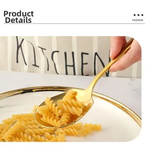 Dettaglio di un grande cucchiaio da portata in acciaio inossidabile dorato con pasta.