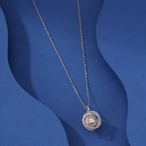 Elegant pearl pendant necklace with sparkling orbital rings on a blue textured background