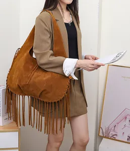 A detailed view of a large brown suede hobo shoulder bag with long stylish fringes