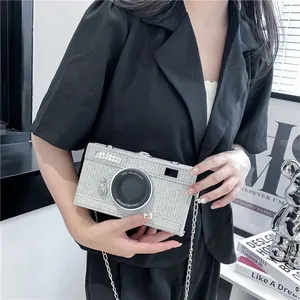 Detailed view of a trendy silver rhinestone camera-shaped clutch bag with chain strap