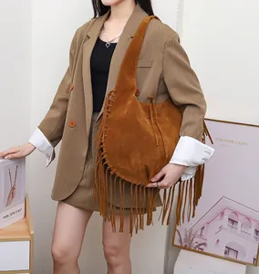 Asian model carrying a large brown suede hobo bag with stylish long fringe details.