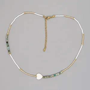 Detailed top view of a beaded heart necklace with turquoise and white accents
