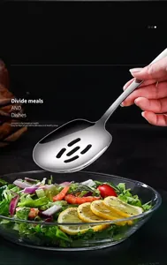 Macro view of 304 stainless steel slotted serving spoon draining oil from fresh salad