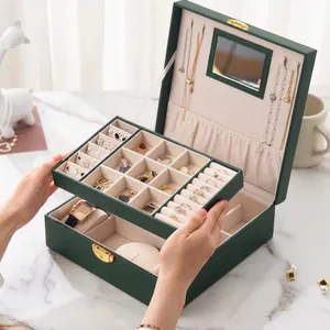 Close-up interior detail of premium dark green jewelry box with removable tray and watch pillows