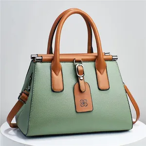 Elegant green litchi grain women's satchel bag with brown handles and crossbody strap