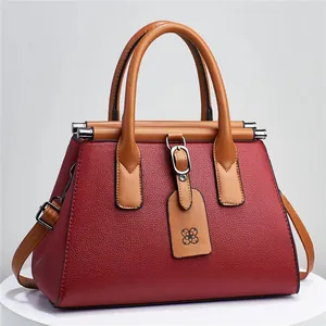 Elegant red and brown lychee grain leather handbag with adjustable crossbody strap.