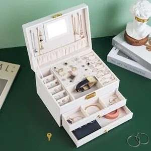 Detail view of multi-layer white jewelry box with compartments for rings and earrings