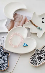 Detail view of heart-shaped white ceramic jewelry tray with crystal accents