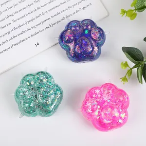 Close-up of three colorful cat paw squishies with glitter and sequins texture detail