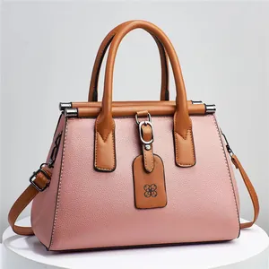 Professional close-up view of a pink lychee grain women's handbag featuring brown top handles