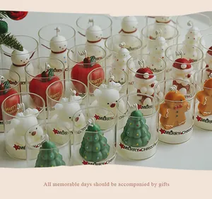 Detailed macro view showing various Christmas themed scented candles in clear glass cups