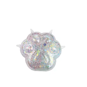 Close-up of translucent cat paw squishy toy with colorful glitter sequins