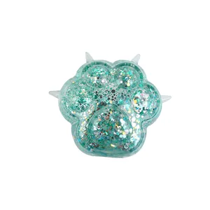 Close-up of a teal glitter cat paw squishy toy with shimmering sequins for stress relief
