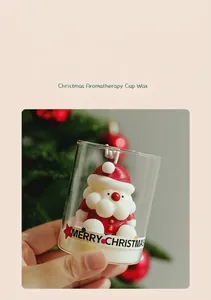 Close-up of a decorative Santa Claus aromatherapy candle inside a glass cup for Christmas