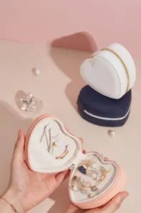 Macro view of the heart-shaped jewelry box interior holding necklaces and earrings.