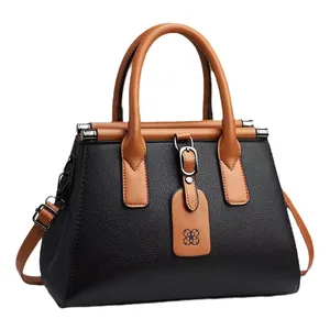 Elegant black lychee pattern handbag with tan handles and a decorative flower tag charm