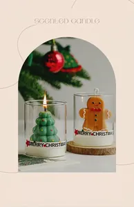Close-up of Christmas tree and gingerbread man shaped scented candles in glass