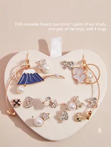 Detail view of a white heart-shaped jewelry insert board for organizing earrings and rings.