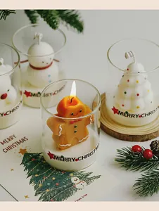 Macro view of Christmas scented candles in glass cups with festive gingerbread man shape.