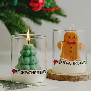 Festive Christmas scented candle set with tree and gingerbread man decor in glass jars.