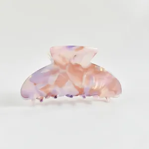 Détail d'une pince à cheveux en acétate à motif marbré rose et violet pour femme