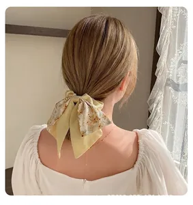 Gros plan d'un chouchou à nœud floral de style Mori avec de longs rubans sur les cheveux