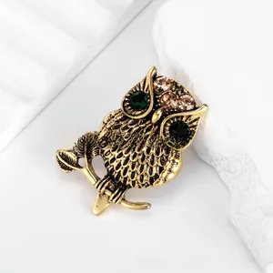 Vintage bronze alloy owl brooch featuring green and brown sparkling rhinestones