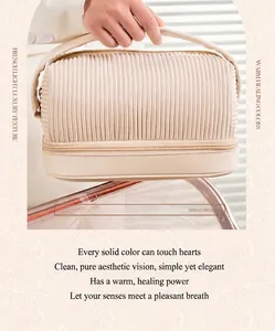 Close-up of pleated cream PU makeup bag showing its unique texture and handle.