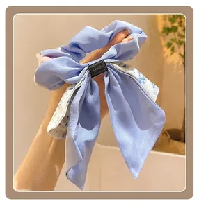 Chouchou à fleurs bleu clair élégant avec long ruban et texture délicate de pétale