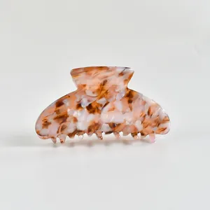 Gros plan d'une pince à cheveux élégante en acétate avec motif écaille de tortue brun