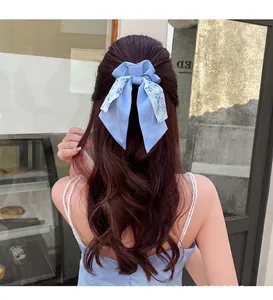 Vue arrière d'un chouchou à nœud floral avec rubans bleus sur cheveux bruns