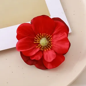 Detailed macro view of a vibrant red artificial magnolia flower head with yellow stamens