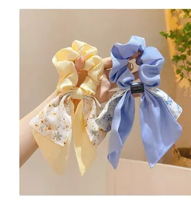 Vue détaillée de chouchous à fleurs avec des rubans élégants en jaune et bleu.