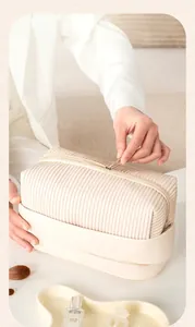 Close-up of a cream-colored textured PU leather cosmetic bag with zipper detail