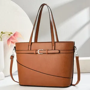 Front view of brown leather tote bag with decorative buckle and adjustable strap