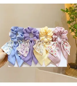 Détail de quatre chouchous à fleurs avec de longs rubans en soie dans un lot