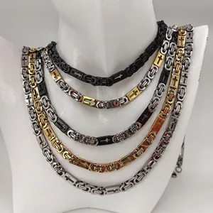 Close-up of assorted stainless steel Byzantine necklaces featuring unique cross motifs.