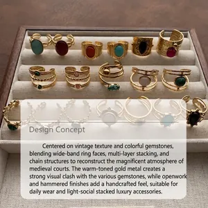 Detailed view of various vintage gold rings with colorful gemstones in a jewelry tray