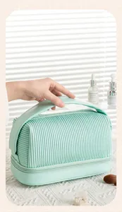 Detail view of mint green PU pleated makeup bag with top handle and double layer