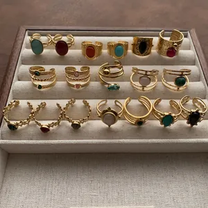 Retro gold-plated adjustable rings with various colorful gemstones in a jewelry box