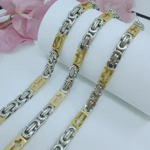Detail view of two-tone stainless steel Byzantine chain necklace with cross motifs
