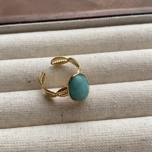 Vintage gold-plated adjustable open ring with oval turquoise gemstone in jewelry box.
