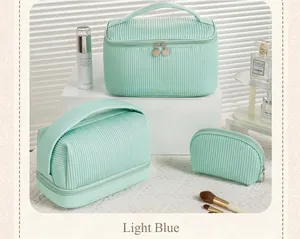 Close-up detail of three mint green pleated PU makeup bags in various sizes and shapes