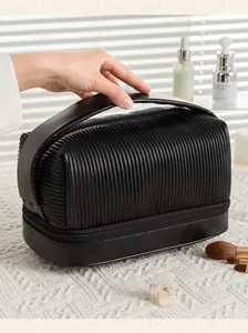 Close-up detail of the black pleated PU leather makeup bag with a sturdy top handle for travel.