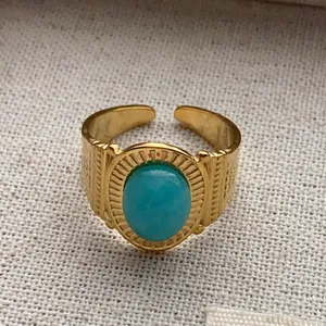 Close-up of retro gold-plated open ring featuring a smooth oval turquoise gemstone