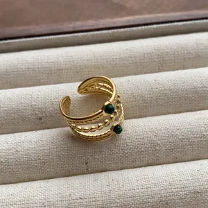 Detail of a vintage gold-plated multi-layer open ring with green malachite stones.