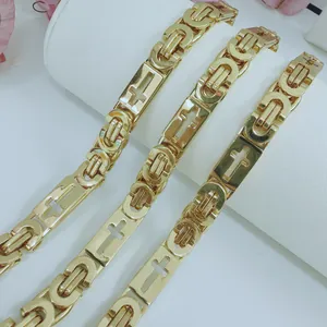 Close-up detail of golden stainless steel Byzantine chain necklace with cross design