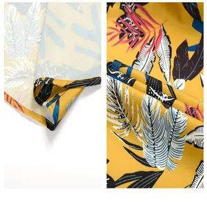 Detailed macro view of yellow Hawaiian beach shirt featuring a colorful palm leaf pattern