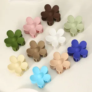 Detail view of 10 matte finish flower shaped hair claw clips in assorted pastel colors.