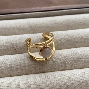 Vintage gold-tone multi-layered open ring featuring a round pale pink gemstone accent